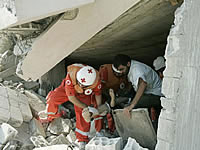 Рятувальники Червоного Хреста витягують з-під розвалин тіло ліванця. Будівля знищена в результаті авіаудару ізраїльських ВВС по селищу Кана (Ліван).
