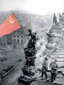 Ця постановочна світлина радянського фотографа Халдея не має відношення до справжнього Прапора Перемоги і є обґрунтовані підозри, що будуть вивішувати саме такі звичайні сталінські прапори СРСР із серпом–молотом